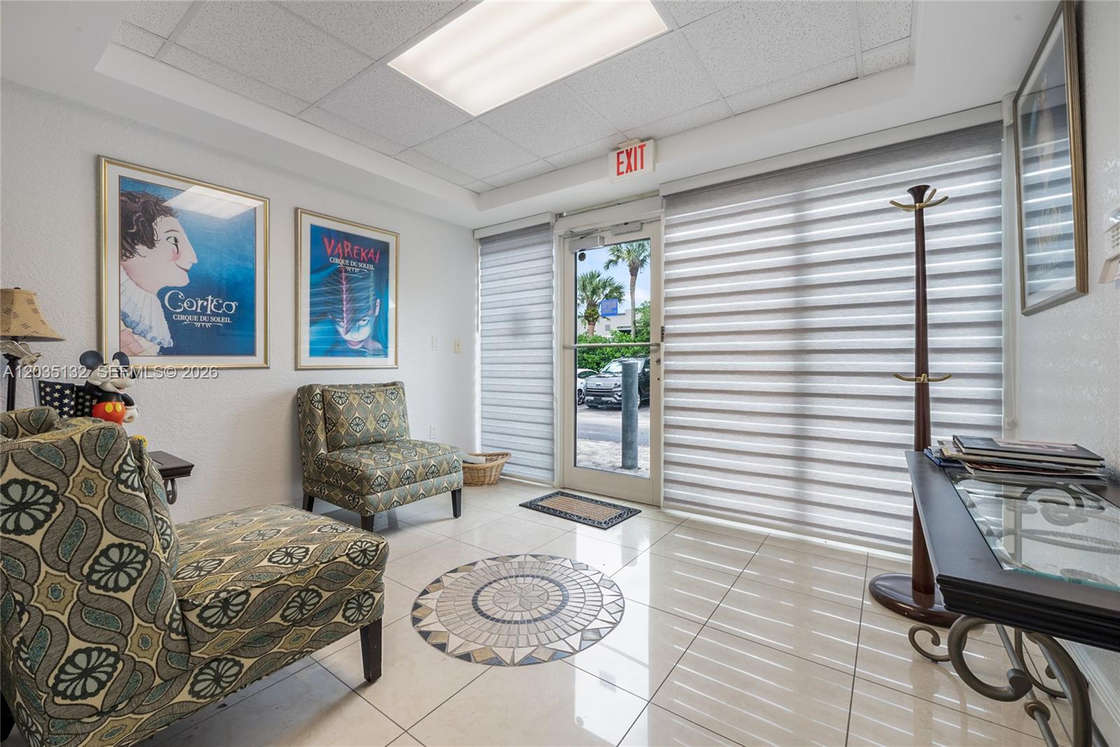 A waiting room features patterned armchairs, tiled floors, a glass-topped table, and a glass entry door — 16155 SW 117th Ave # B21, Miami FL 33177, MIAMI, FL