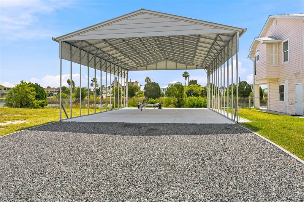 An aerial view of a two-story house with a metal roof, dock, and carport — 3342 TURKS CAP DRIVE, HERNANDO BEACH, FL
