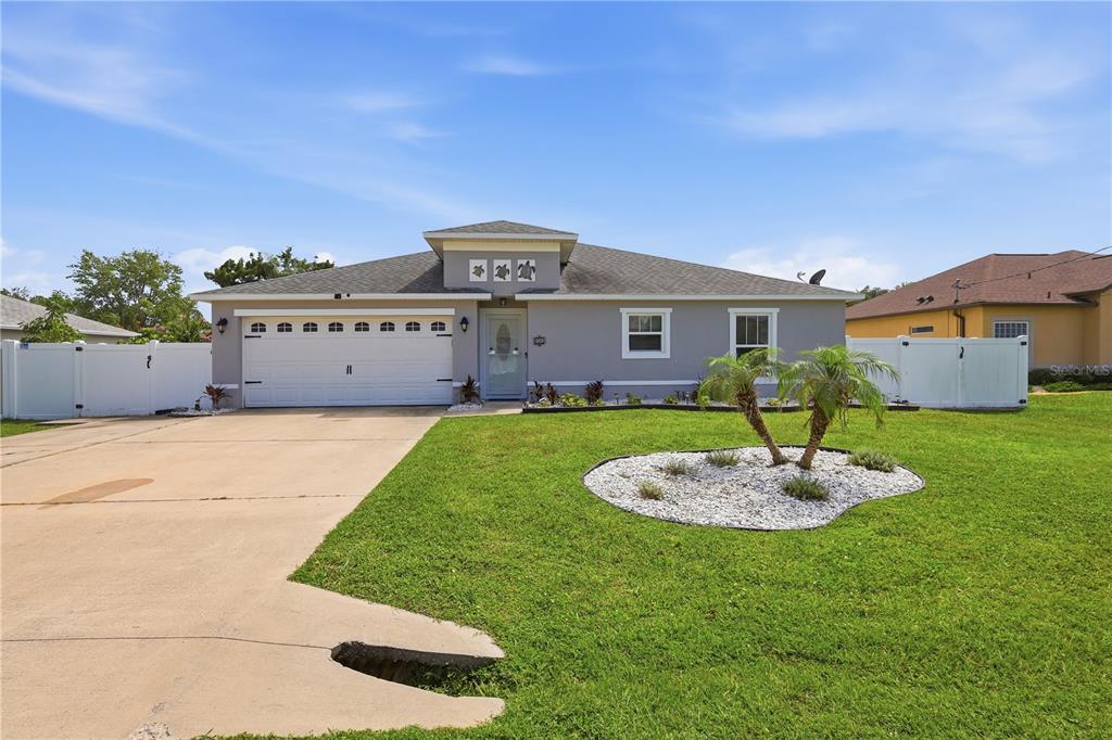 A single-story house with a gray exterior, a two-car garage, and a front lawn — 36 ROYAL PALM LANE, PALM COAST, FL
