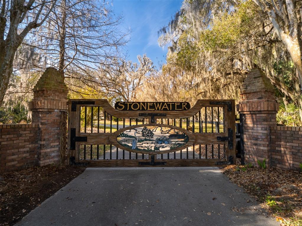 A gated entrance featuring a wooden sign reading Stonewater between two brick pillars — 4986 SW 7TH AVENUE ROAD, OCALA, FL