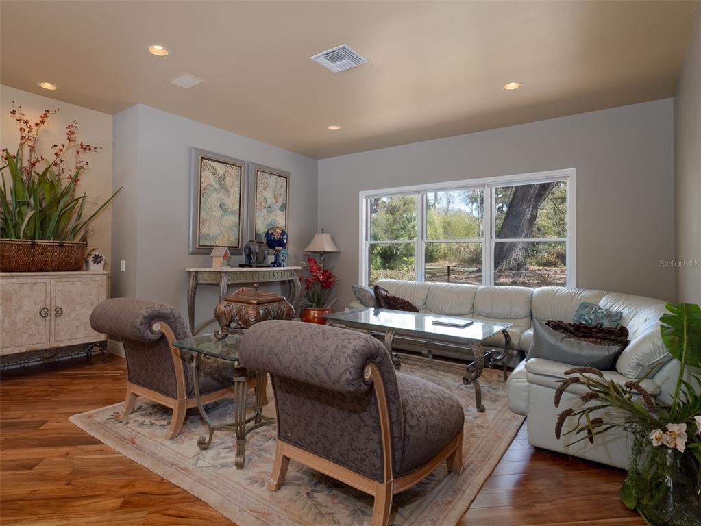 A living room features a white sectional sofa, two patterned armchairs, and hardwood floors — 4986 SW 7TH AVENUE ROAD, OCALA, FL