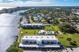 An aerial view shows low-rise apartment buildings situated along a waterway near a residential neighborhood — 100 Waterway Rd # A306, Tequesta FL 33469, TEQUESTA, FL