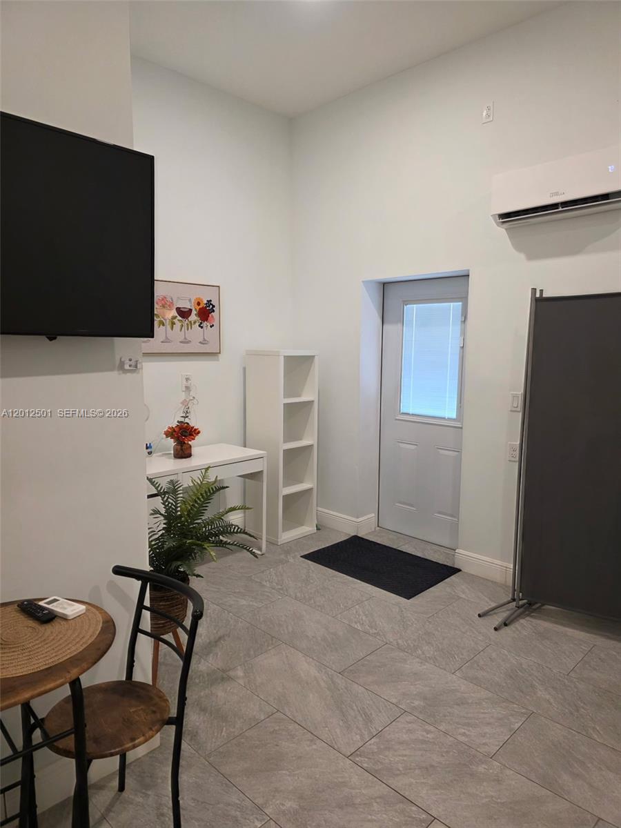 A room features light gray tile flooring, a white desk, a bookshelf, and a door — HOMESTEAD, FL