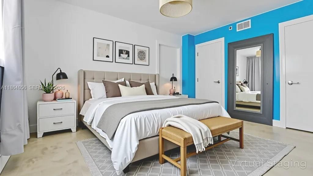 This virtually staged living and dining area features a blue accent wall and breakfast bar — 865 Collins Ave # 207, Miami Beach FL 33139, MIAMI BEACH, FL