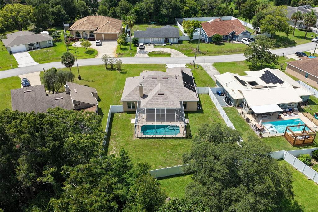 An aerial view shows a suburban house with a screened pool and a fenced backyard — 62 FORRESTER PLACE, PALM COAST, FL