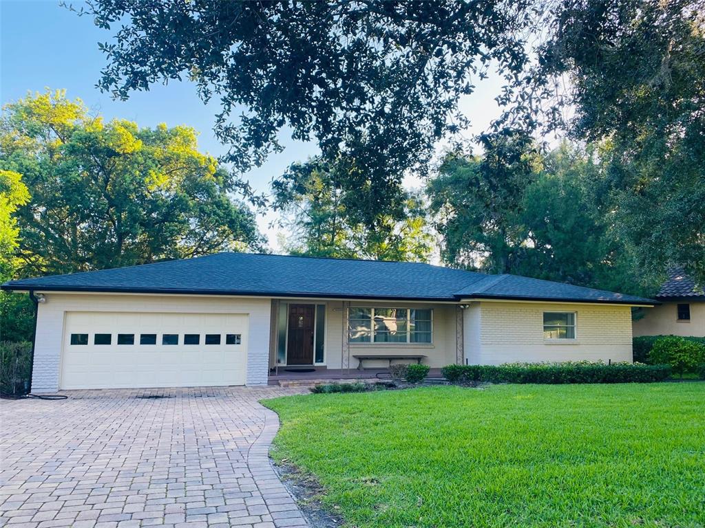 A single-story house with a brick exterior, a paved driveway, and a large front lawn — 1113 VIA DEL MAR, WINTER PARK, FL