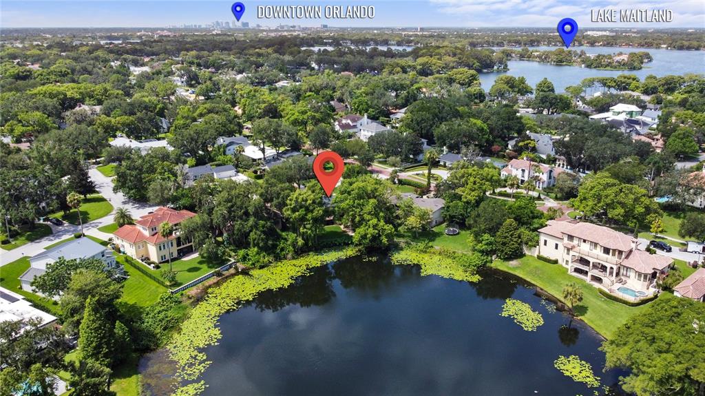 An aerial view shows a house nestled among trees beside a small, lily-covered lake — 1113 VIA DEL MAR, WINTER PARK, FL