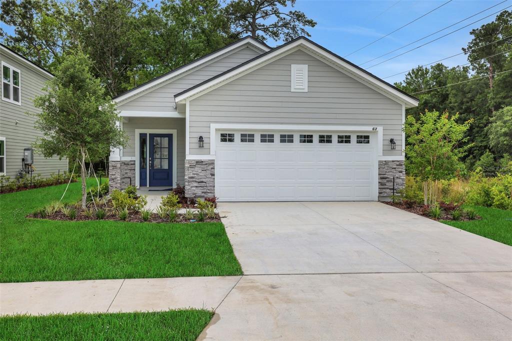 A single-story house with gray siding, a white garage door, and a blue front door — 530 FARMFIELD DRIVE, ST AUGUSTINE, FL