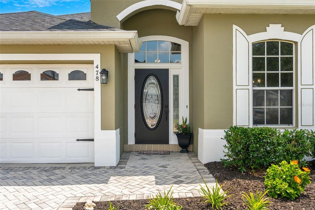 The exterior of a house features a garage, a dark front door, and a window — 478 SYCAMORE SPRINGS STREET, DEBARY, FL