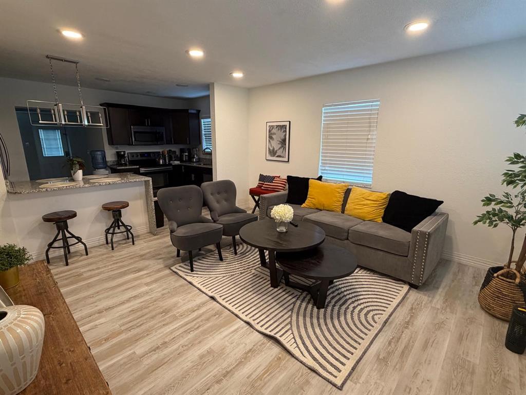 A living room features a grey sofa, two armchairs, a coffee table, and kitchen access — 4714 W LAWN AVENUE, TAMPA, FL
