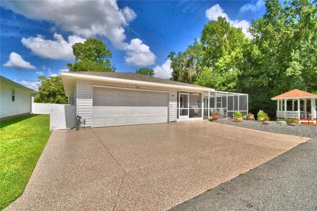 A single-story house with a white garage, screened-in porch, and a gazebo in the yard — 4789 SQUIRE HOLLOW DRIVE, LAKELAND, FL