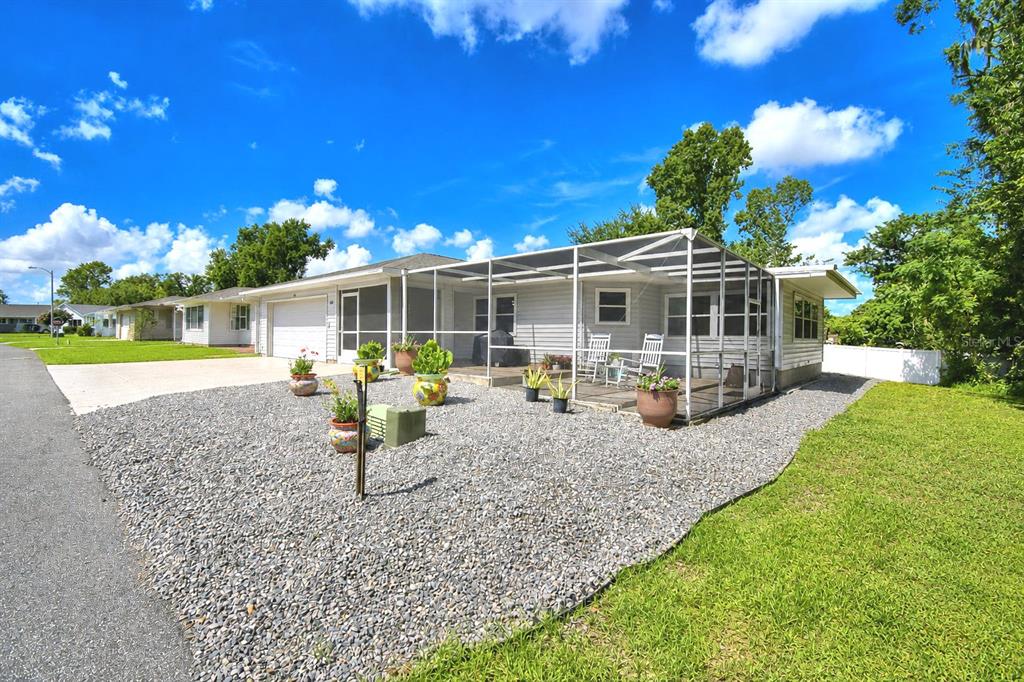 A single-story house with a screened-in porch and a gravel front yard — 4789 SQUIRE HOLLOW DRIVE, LAKELAND, FL
