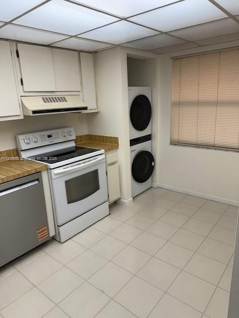 A kitchen features white cabinets, a white stove, a dishwasher, and a stacked laundry unit — 400 Commodore Dr # 108, Plantation FL 33325, PLANTATION, FL
