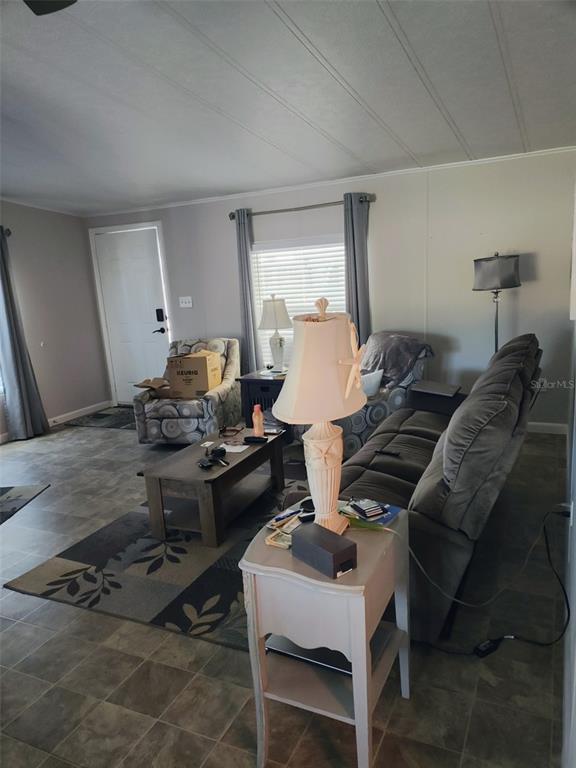 A living room features a gray sofa, patterned armchair, coffee table, and a lamp on a side table — 15550 BURNT STORE ROAD UNIT 236, PUNTA GORDA, FL