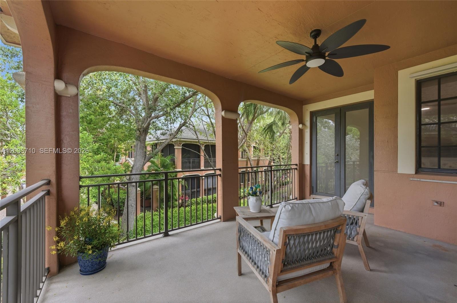 A covered balcony features a ceiling fan, two chairs, a small table, and metal railings — 2794 Kinsington Cir # 3, Weston FL 33332, WESTON, FL