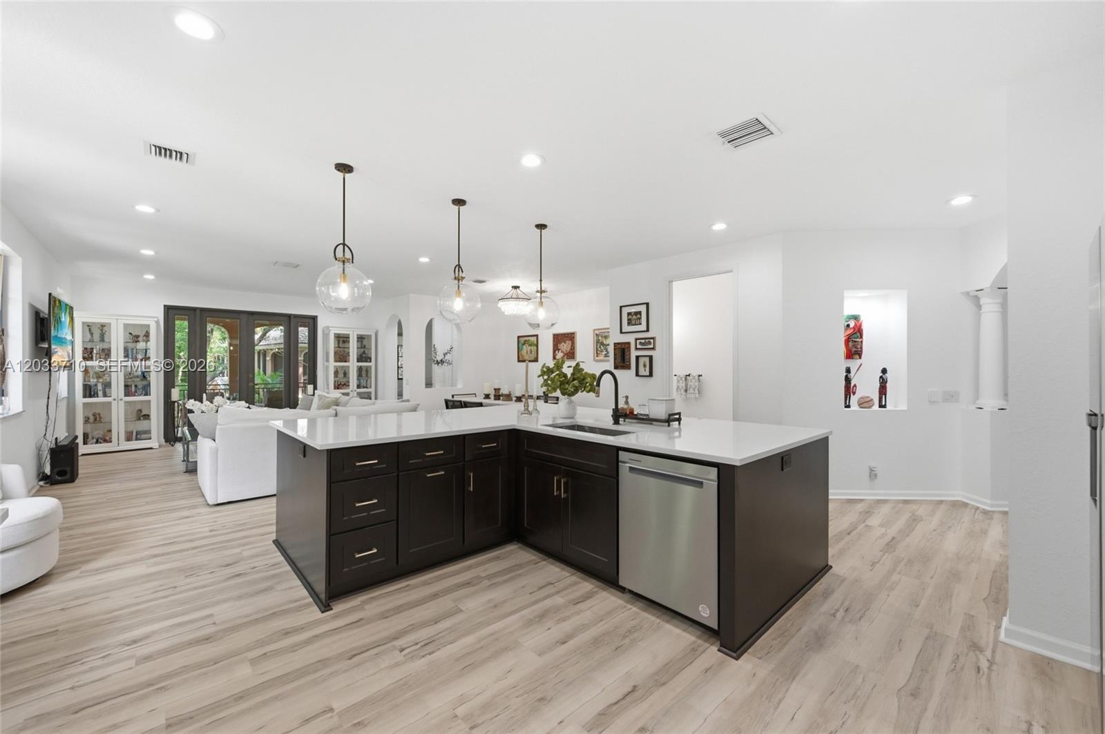 A modern kitchen features dark wood cabinets, white countertops, and stainless steel appliances — 2794 Kinsington Cir # 3, Weston FL 33332, WESTON, FL