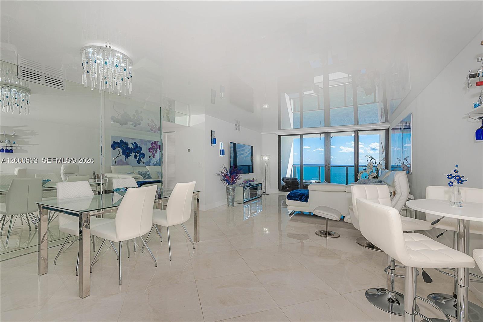 A bright, modern living and dining area features white furniture, tiled floors, and ocean views — 2301 S Ocean Dr # 2003, Hollywood FL 33019, HOLLYWOOD, FL