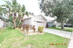 A light-colored single-story house with a garage and a large tree in the front yard — 504 MAPLE POINTE DRIVE, SEFFNER, FL