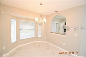 A dining area features light-colored tile flooring, a chandelier, and a pass-through window to the kitchen — 504 MAPLE POINTE DRIVE, SEFFNER, FL
