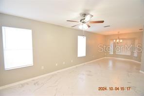 A bright, empty room features light-colored walls, a ceiling fan, and white marble-look flooring — 504 MAPLE POINTE DRIVE, SEFFNER, FL