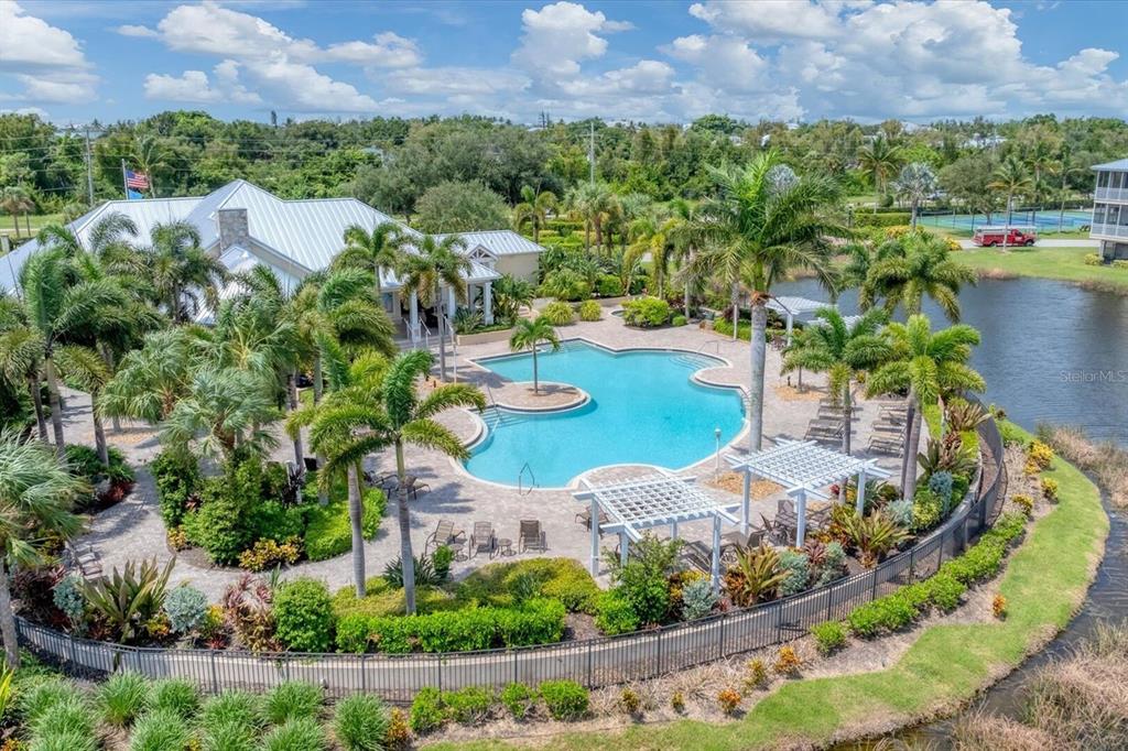 An aerial view of a swimming pool with a pergola, palm trees, and a clubhouse — 10420 CORAL LANDINGS LANE UNIT 115, PLACIDA, FL