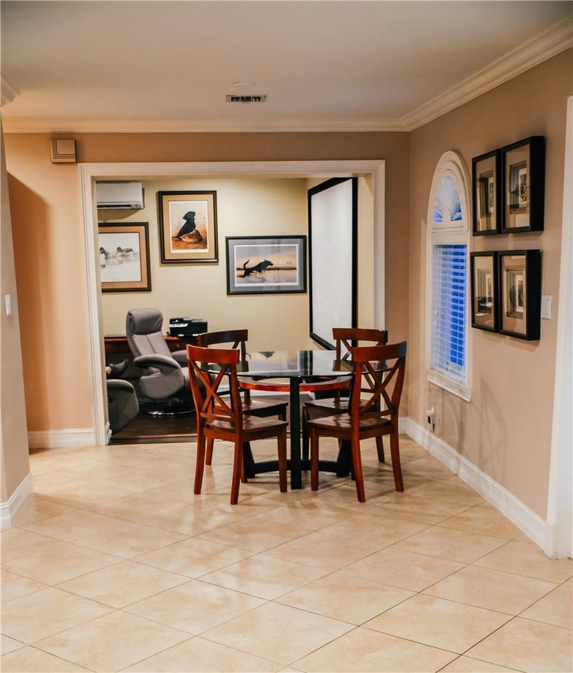 A dining area with a glass table and four chairs opens into a home office — 5051 NE 24th Avenue, Lighthouse Point FL 33064, LIGHTHOUSE POINT, FL