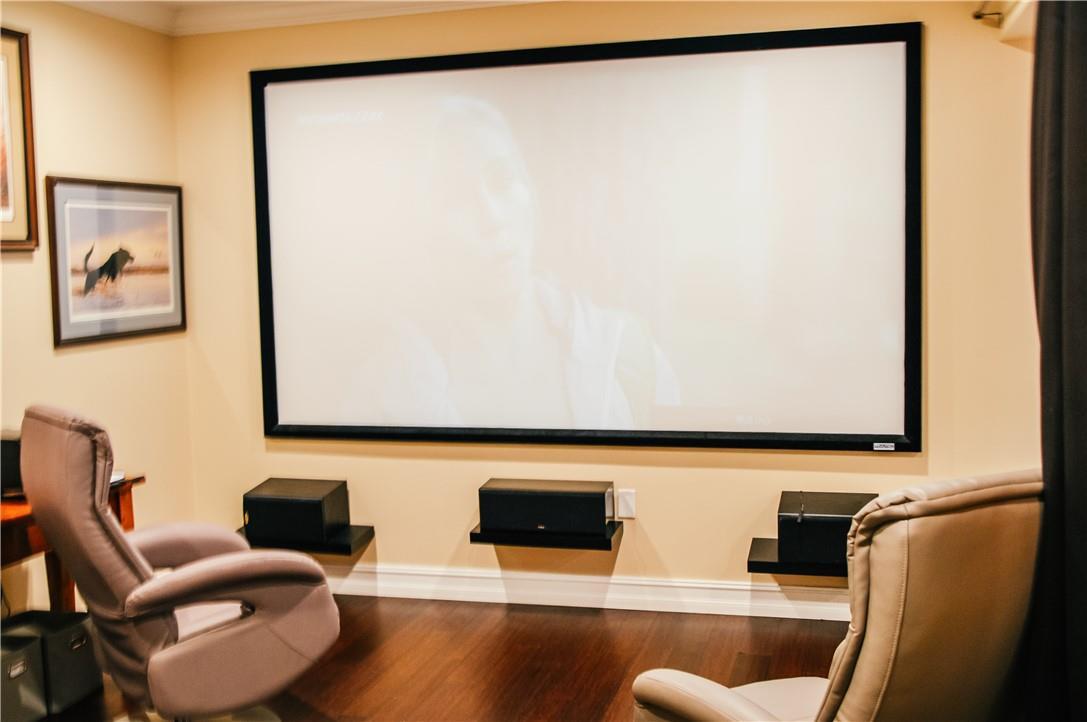 A home theater room features a large projection screen, wall-mounted speakers, and two leather recliners — 5051 NE 24th Avenue, Lighthouse Point FL 33064, LIGHTHOUSE POINT, FL