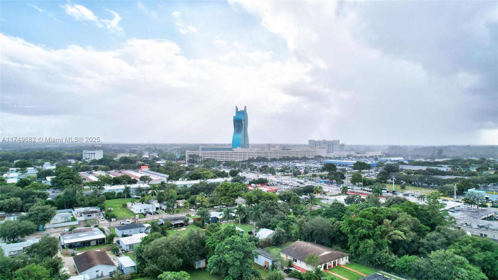 An aerial view shows a residential neighborhood with a large, distinctive guitar-shaped hotel in the distance — 4381 SW 51st St, Dania Beach FL 33314, DANIA BEACH, FL
