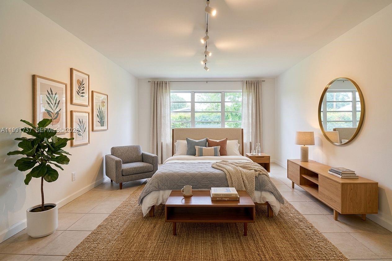 A bedroom features a bed, a wooden bench, a gray armchair, and a round mirror — 8285 SW 104th St, Miami FL 33156, MIAMI, FL