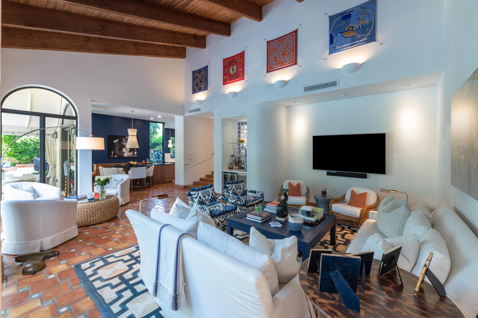 A spacious living room features terracotta tile floors, a vaulted wood-beam ceiling, and white furniture — 264 Everglade Avenue, Palm Beach FL 33480, PALM BEACH, FL