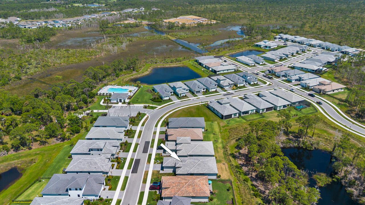 An aerial view shows a suburban neighborhood with houses, a community pool, and surrounding wetlands — 6980 SE Haven Lane, Stuart FL 34997, STUART, FL