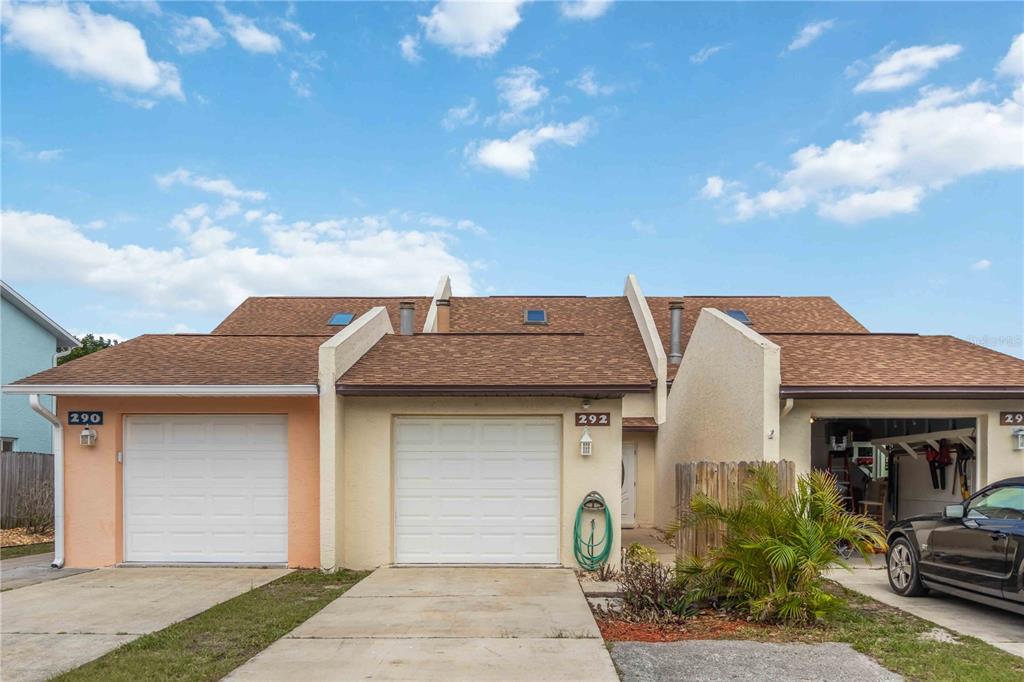 A row of three attached single-story residential units with garages and brown shingled roofs — 292 CANAVERAL BEACH BOULEVARD, CAPE CANAVERAL, FL