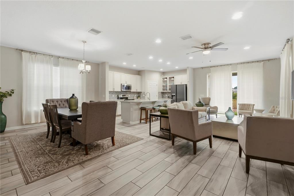 A view from a hallway looking into an open-concept living room and kitchen area — 205 ABERDEEN STREET, DAVENPORT, FL