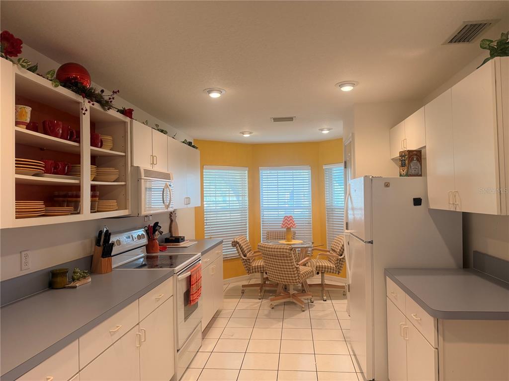 A kitchen with white cabinets, light countertops, and a breakfast nook with a table — 6157 W CANNONDALE DRIVE, CRYSTAL RIVER, FL