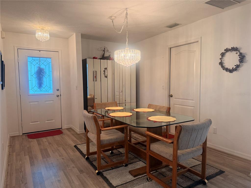 A dining room features a glass-topped table, four wooden chairs, and two crystal chandeliers — 6157 W CANNONDALE DRIVE, CRYSTAL RIVER, FL