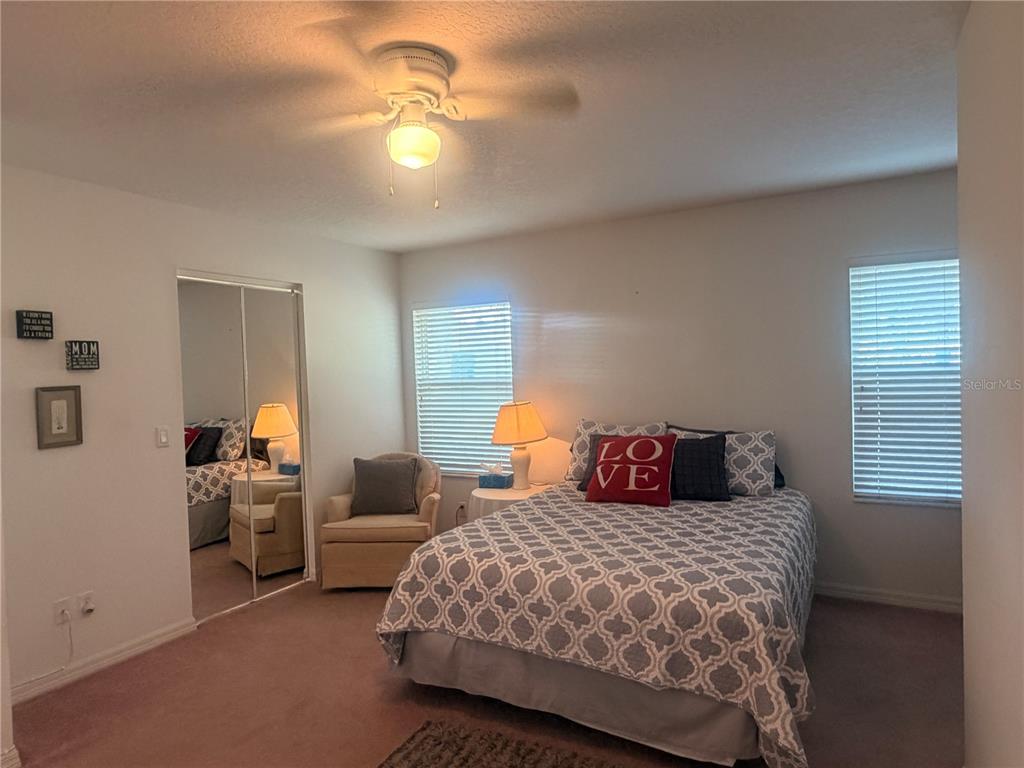 A bedroom features a bed with a patterned quilt, a ceiling fan, and mirrored closet doors — 6157 W CANNONDALE DRIVE, CRYSTAL RIVER, FL