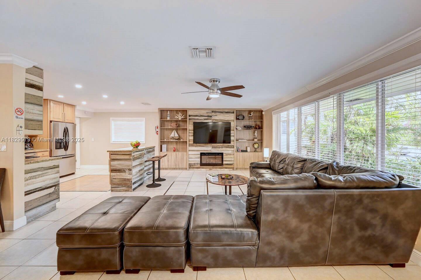 A living room features a large sectional sofa, a fireplace, and a kitchen island — 1228 Johnson St, Hollywood FL 33019, HOLLYWOOD, FL