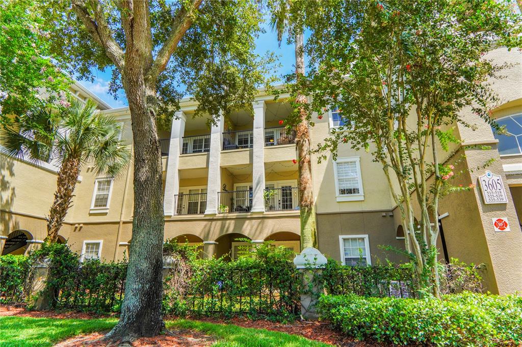 A three-story apartment building with balconies, white columns, and a landscaped front yard — 3605 CONROY ROAD UNIT 535, ORLANDO, FL