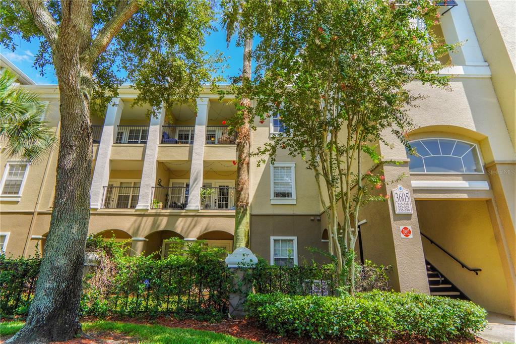 A three-story apartment building exterior features balconies, white columns, and a tan stucco facade — 3605 CONROY ROAD UNIT 535, ORLANDO, FL