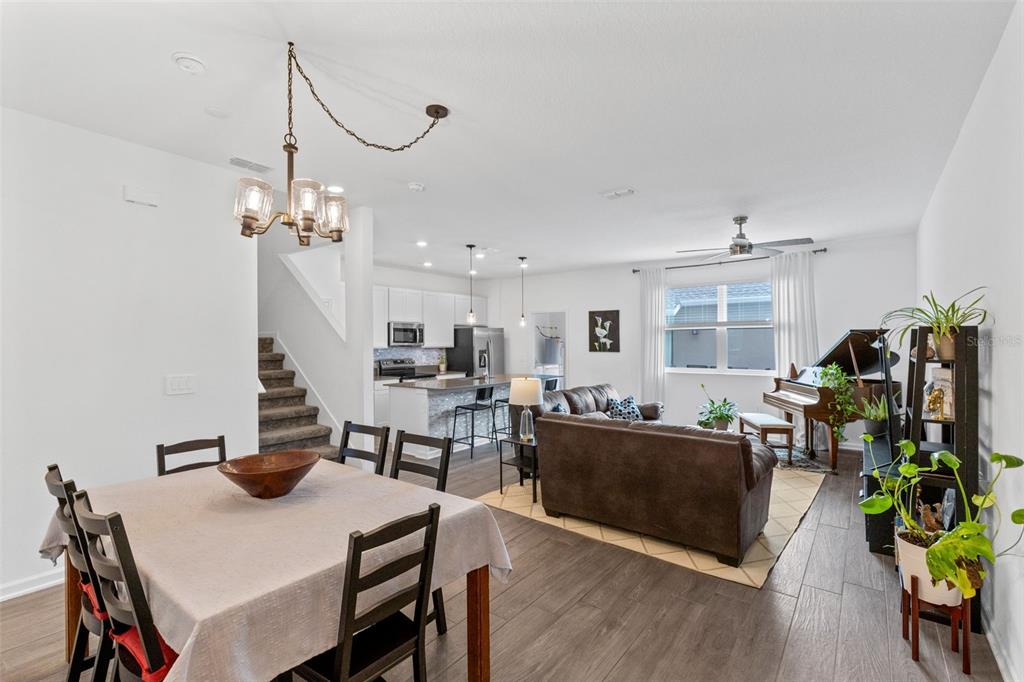 An open-concept living area features a dining space, kitchen with island, and a living room — 10607 WORDS DRIVE, WINTER GARDEN, FL