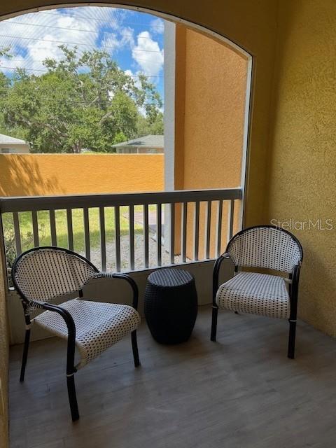 A screened-in patio features two woven chairs and a small black side table — 10764 70TH AVENUE UNIT 1106, SEMINOLE, FL