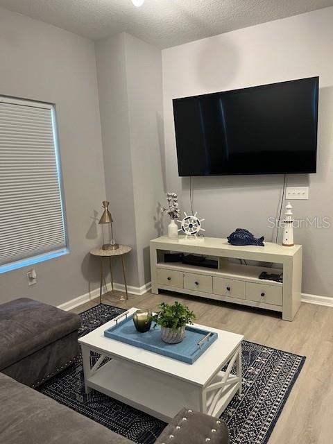 A living room features a wall-mounted television, a white media console, and a coffee table — 10764 70TH AVENUE UNIT 1106, SEMINOLE, FL