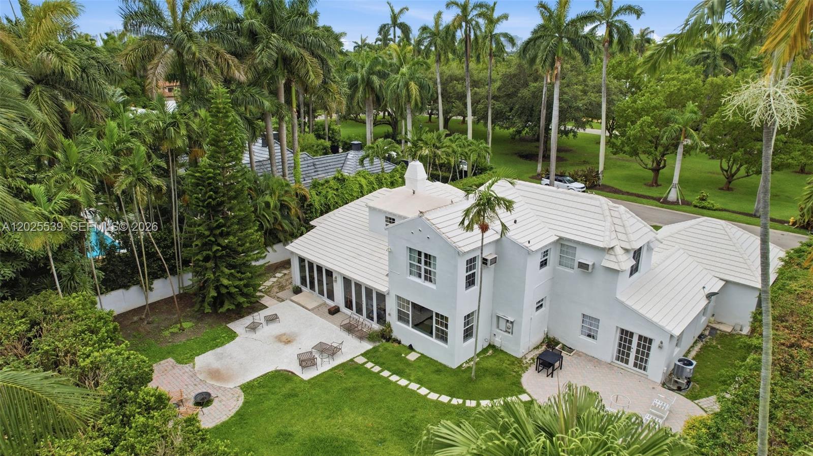 An aerial view shows a white two-story house with a metal roof and patio — 2535 Sunset Dr, Miami Beach FL 33140, MIAMI BEACH, FL