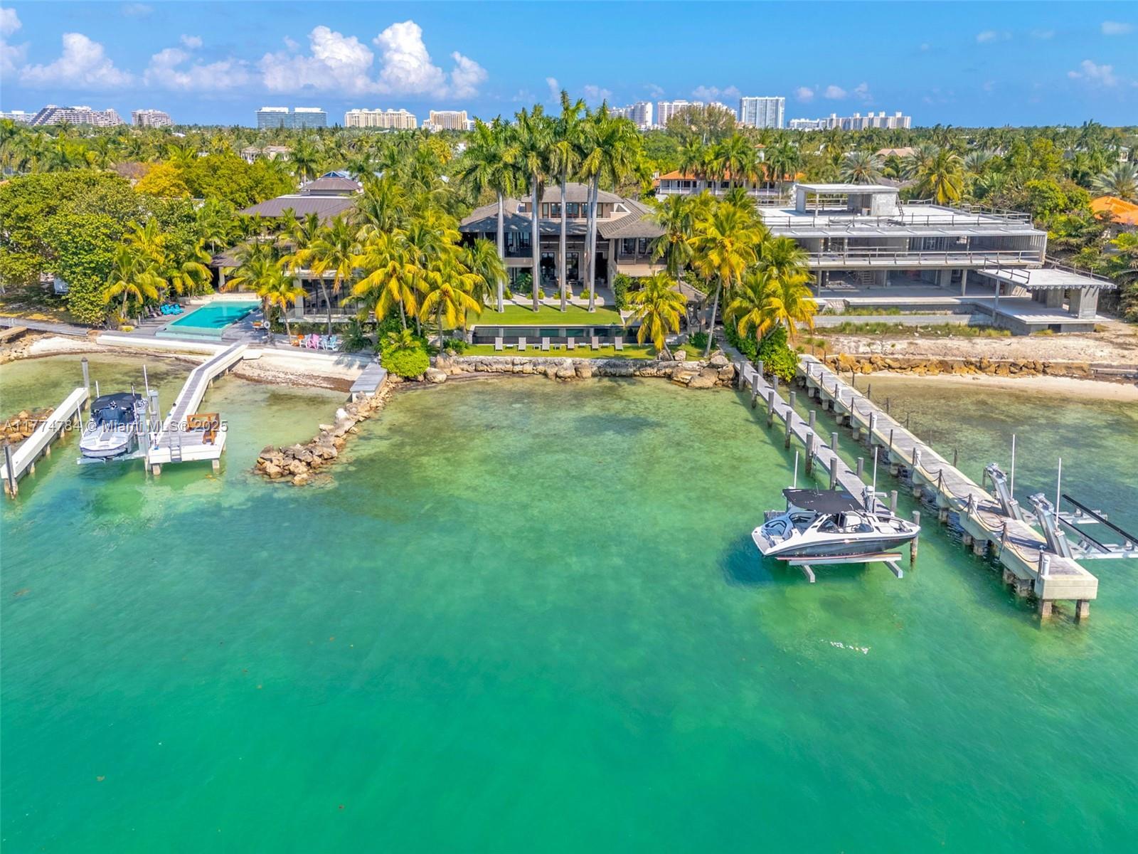 An aerial view of a waterfront estate featuring two docks, boats, and a swimming pool — 9 Harbor Pt, Key Biscayne FL 33149, KEY BISCAYNE, FL