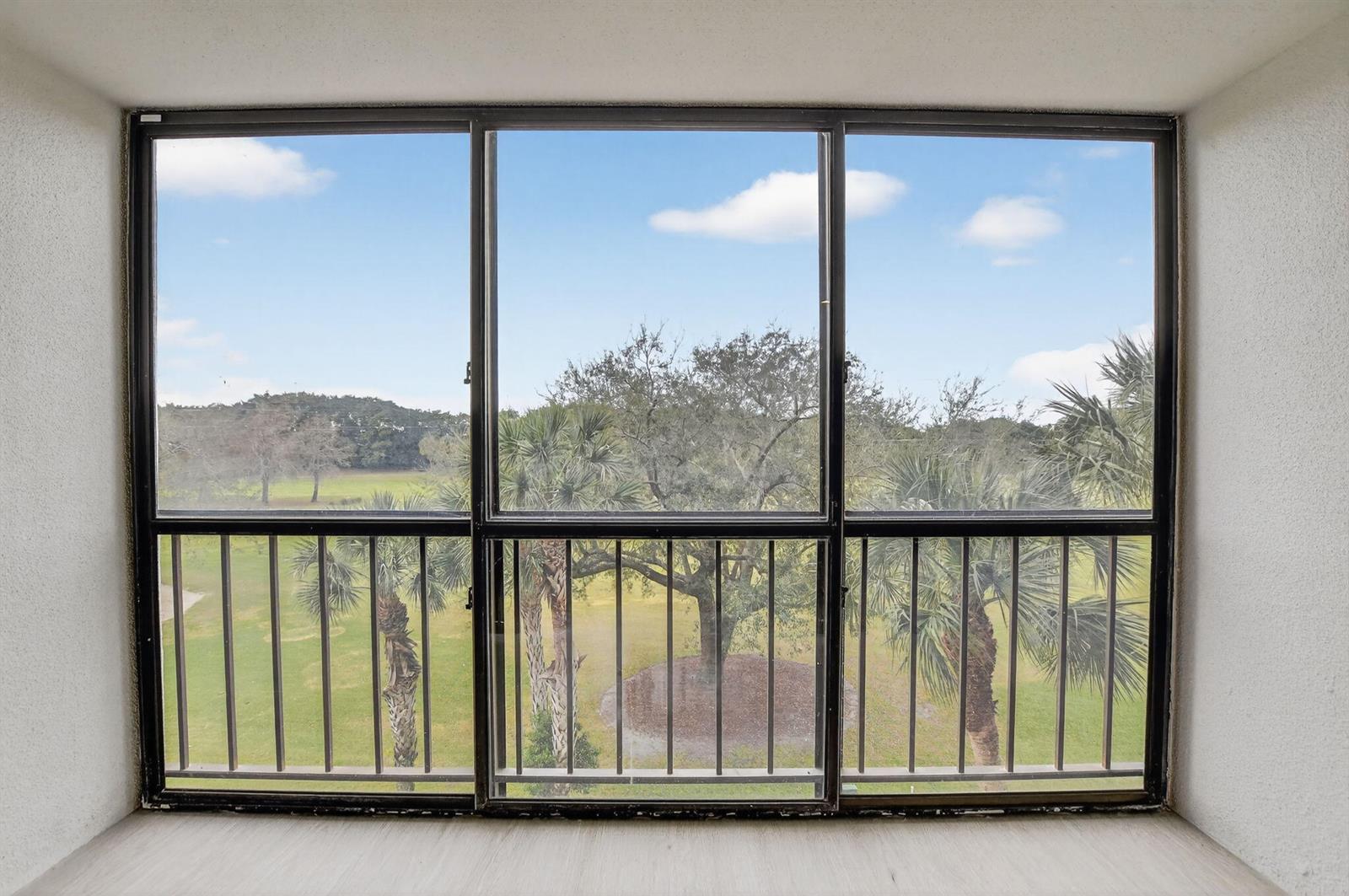 A room with a large three-panel window overlooking a grassy area with trees — 7835 Lakeside Boulevard # 946, Boca Raton FL 33434, BOCA RATON, FL