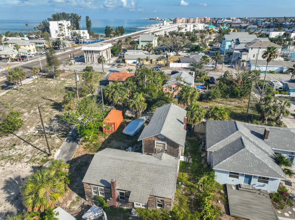 An aerial view shows two houses, a storage container, and a boat near a bridge — 108 125TH AVENUE, TREASURE ISLAND, FL