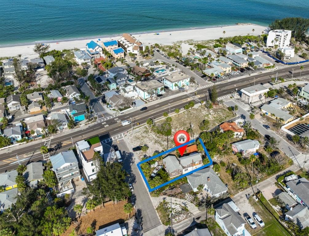 An aerial view shows a residential property outlined in blue near a beach — 108 125TH AVENUE, TREASURE ISLAND, FL