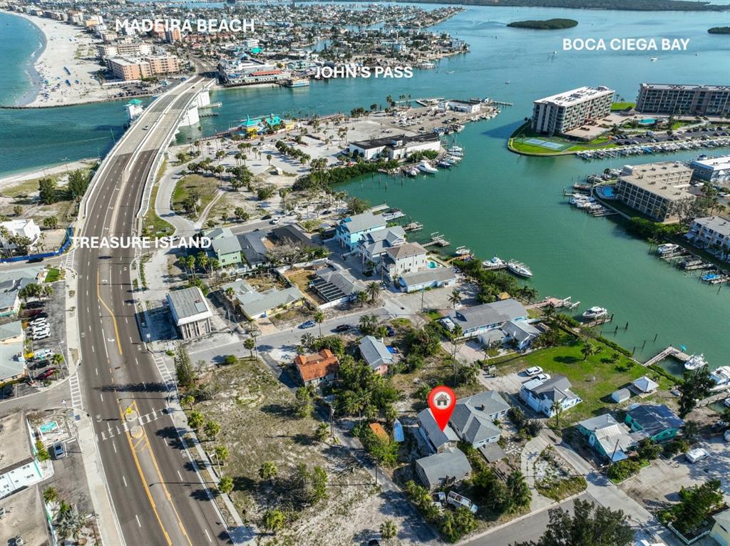 An aerial view shows a house with a red location pin near a coastal waterway — 108 125TH AVENUE, TREASURE ISLAND, FL