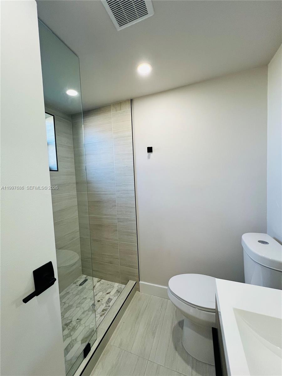 A modern bathroom features a glass-enclosed shower with tiled walls, a toilet, and a vanity — 3826 SW 107th Ave # 2, Miami FL 33165, MIAMI, FL