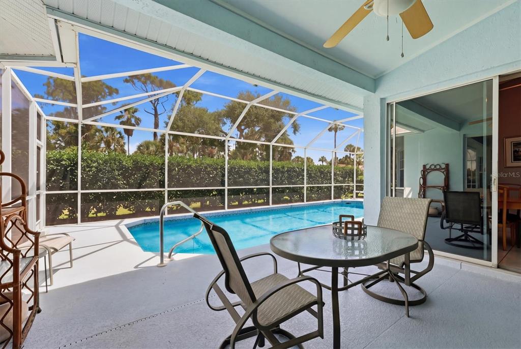 A covered patio features a swimming pool, outdoor furniture, and a screened-in enclosure — 1787 KILRUSS DRIVE, VENICE, FL